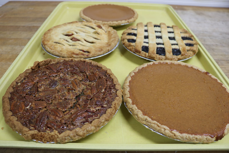 Photo of 5 pies: Pumpkin Pie, Blackberry Pie, Strawberry Rhubarb Pie, and Pecan Pie.